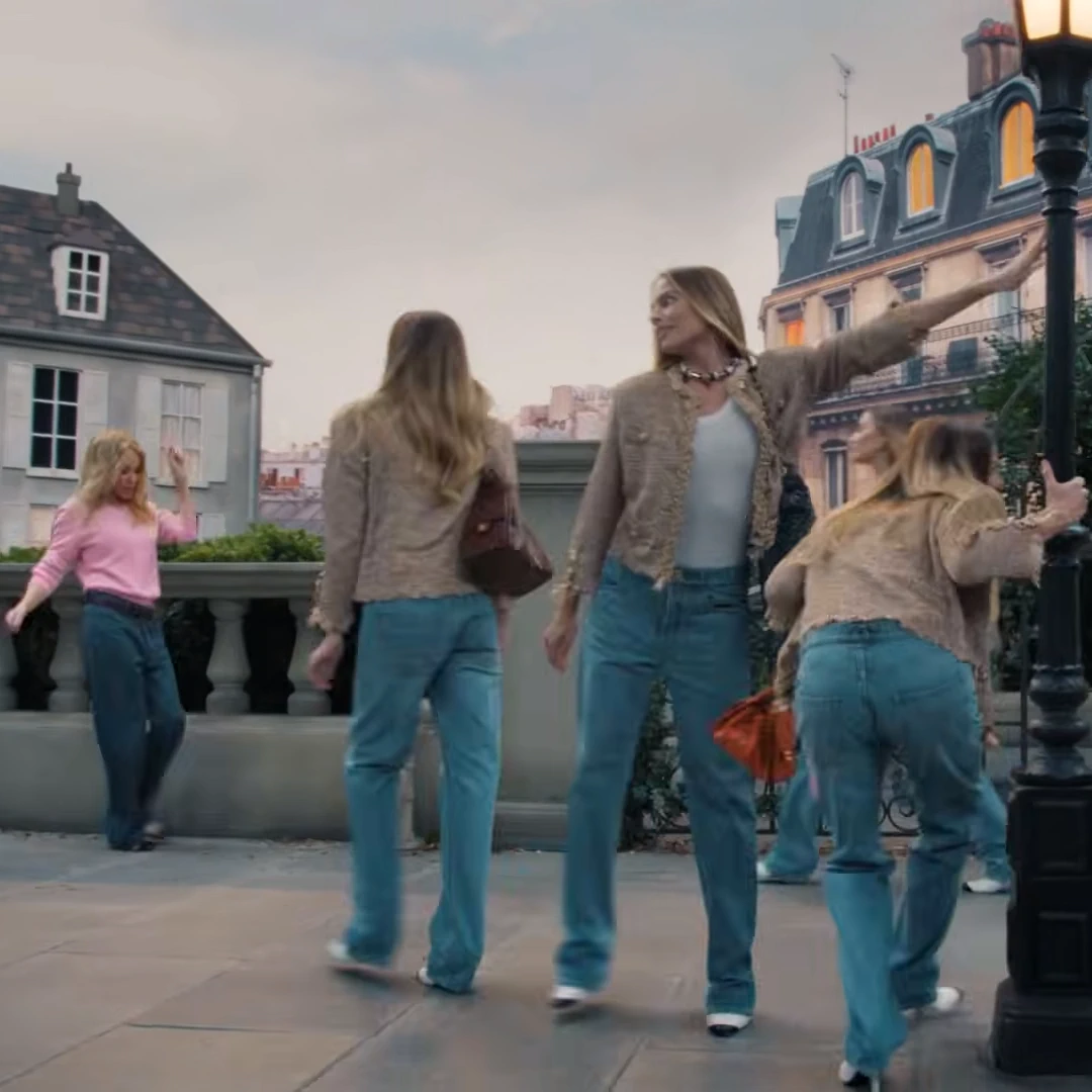 Margot Robbie se multiplica en el video para Chanel, al fondo aparece Kylie Minogue, pantalón denin y jersey rosa, ambos de Chanel.webp