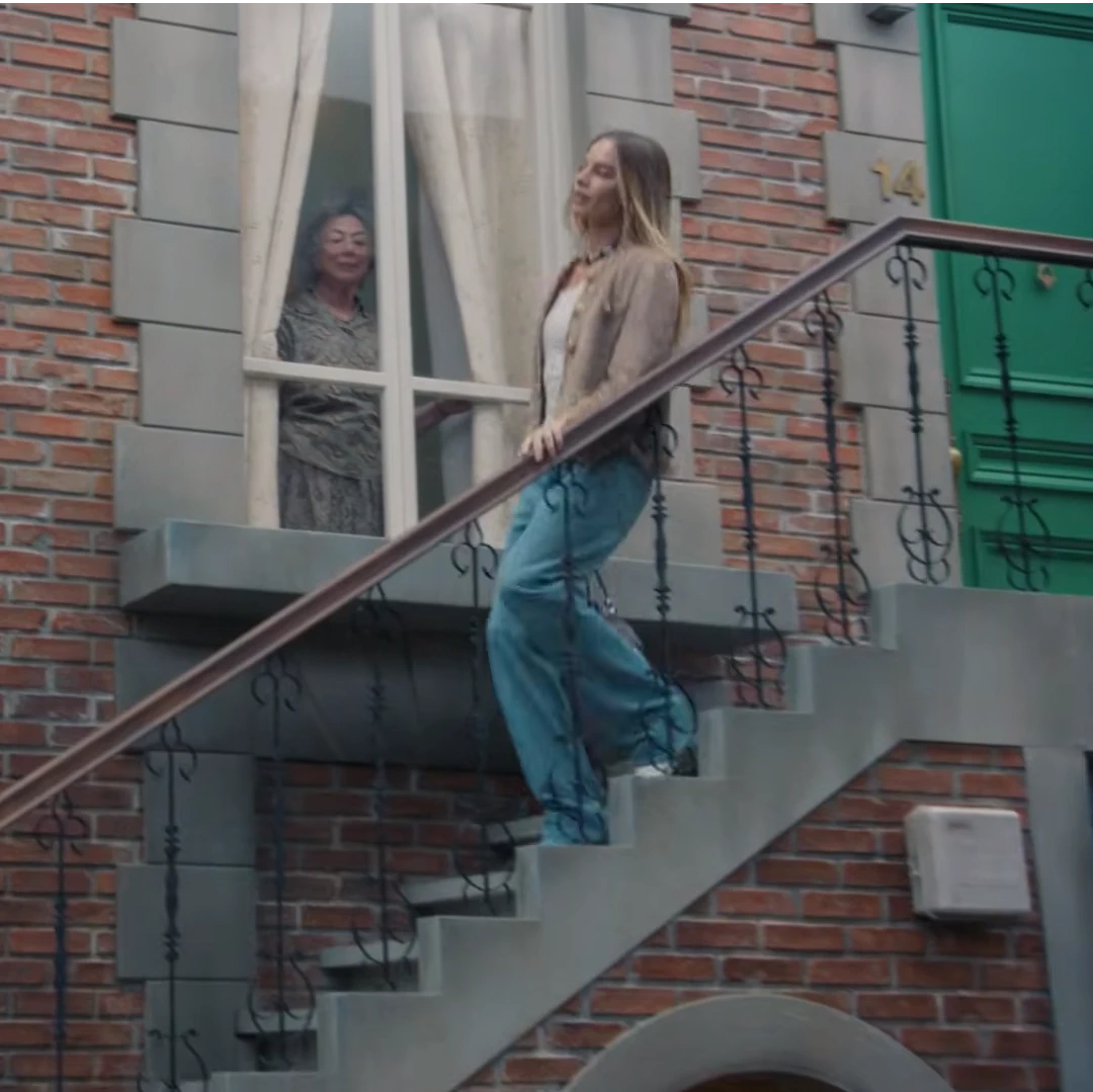 Margot Robbie desciende por la escalera, video para Chanel, promoción del bolso Chanel 25.webp
