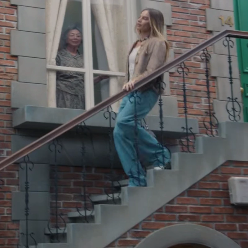 Margot Robbie desciende por la escalera, video para Chanel, promoción del bolso Chanel 25.2..webp